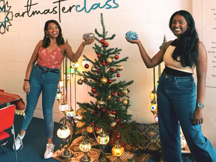 Guests celebrating together beside a Christmas tree