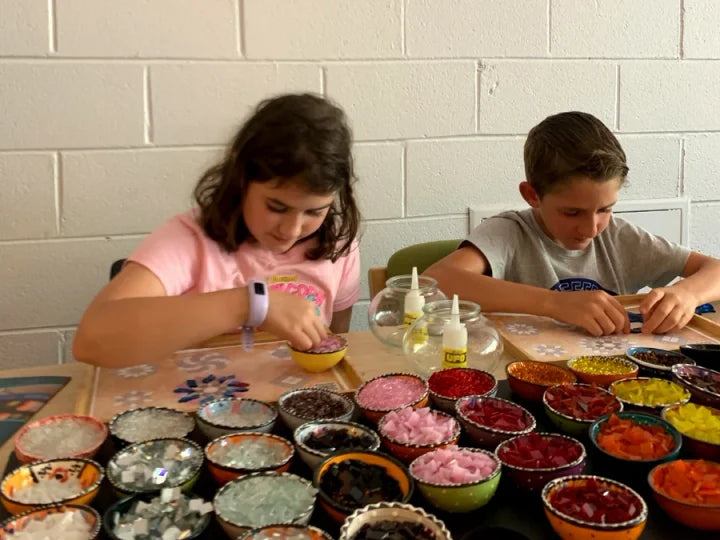 Children choosing colourful pieces for their mosaic project