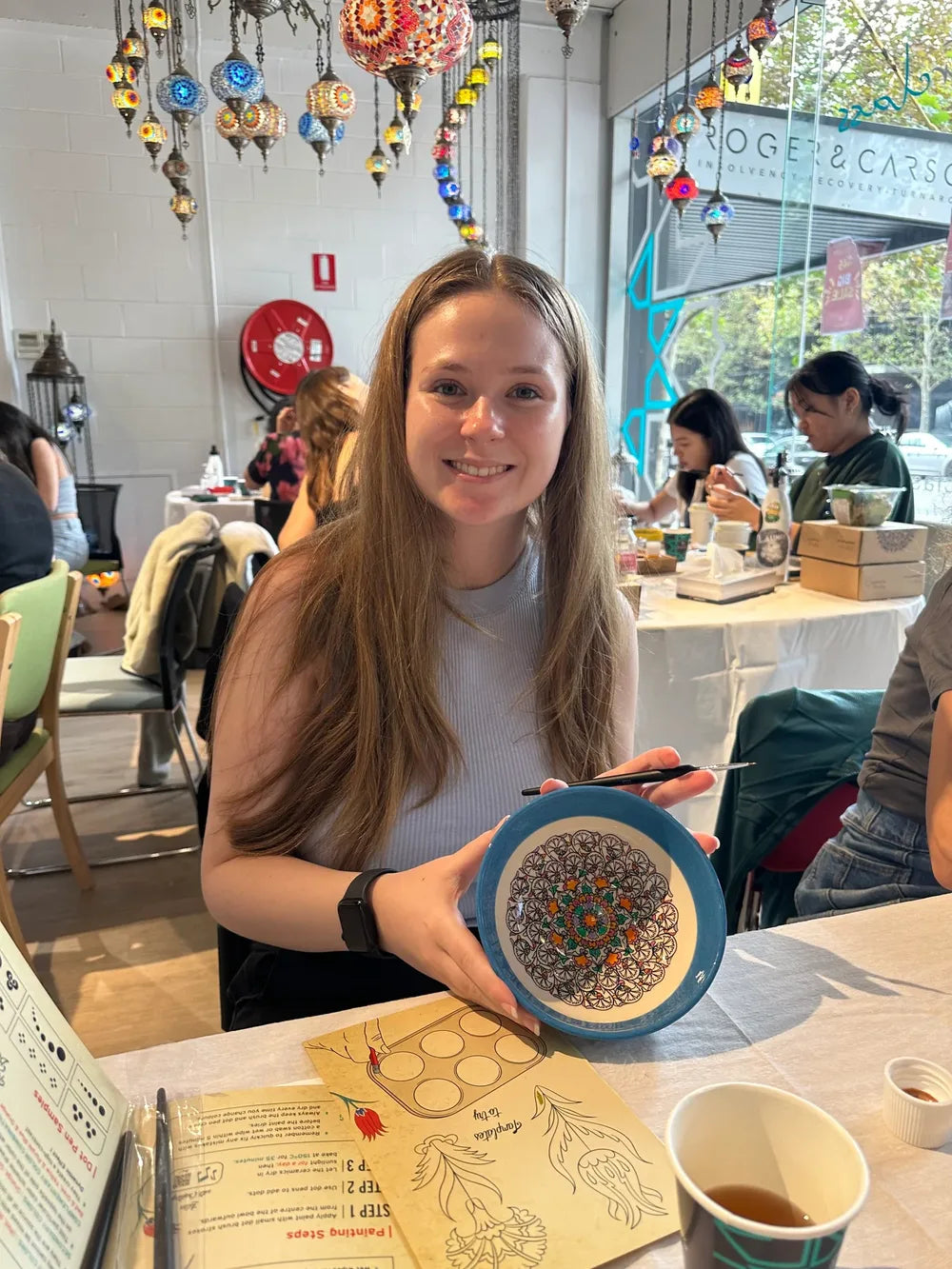 Guest with a finished blue and yellow ceramic painting